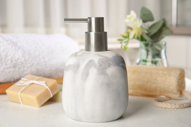 Soap dispenser and toiletries on white table