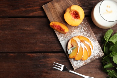 Delicious peach dessert on wooden table, flat lay. Space for text