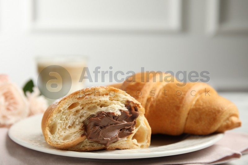 Tasty croissants with chocolate on table, closeup. Space for text