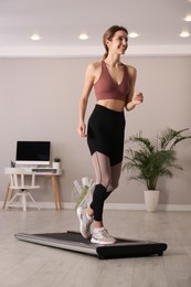 Sporty woman training on walking treadmill at home