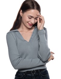 Embarrassed young woman covering face with hand on white background