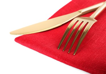 Red napkin with golden fork and knife on white background, closeup