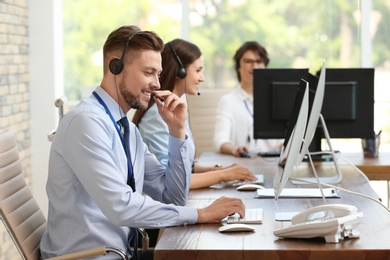 Technical support operators with headsets at workplace