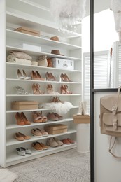 Dressing room interior with stylish shoes and accessories on shelves