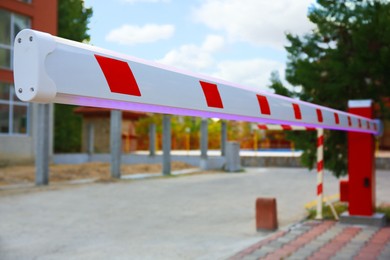 Closeup view of closed automatic boom barrier outdoors, space for text