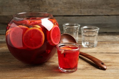 Aromatic punch drink with citrus fruits on wooden table