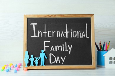 Photo of Happy Family Day. Composition with blackboard and stationery on white wooden table