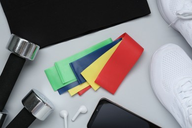 Photo of Flat lay composition with fitness elastic bands on light background
