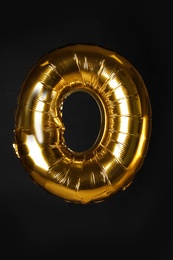Photo of Golden letter O balloon on black background