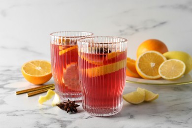 Aromatic punch drink and ingredients on white marble table