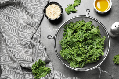 Raw cabbage leaves on grey table, flat lay. Preparing kale chips