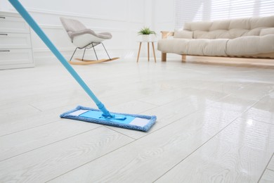 Washing of parquet floor with mop in room, closeup. Space for text