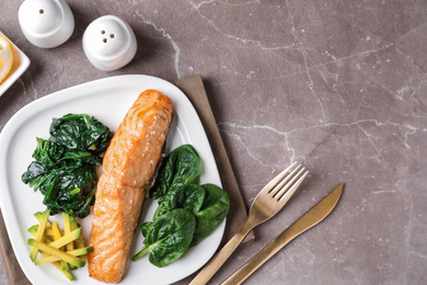 Tasty salmon with spinach and avocado served on marble table, flat lay. Space for text
