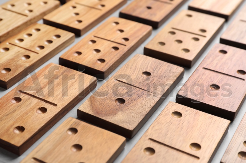 Set of wooden domino tiles on grey table, closeup