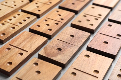 Set of wooden domino tiles on grey table, closeup