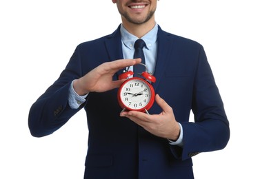 Happy businessman holding alarm clock on white background, closeup. Time management