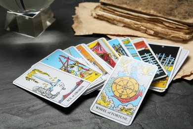Wheel of Fortune and other tarot cards on black table