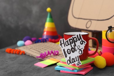 Cup with words Happy Fool's Day at fake workplace in office