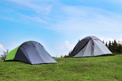 Small camping tents in mountains on sunny day