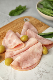 Ham with olives and spinach on table