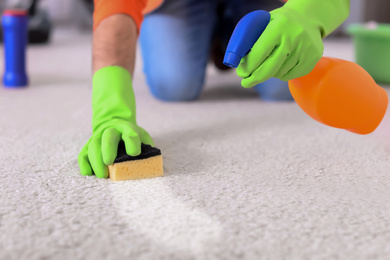 Image of Man removing dirt from carpet at home, closeup. Cleaning service
