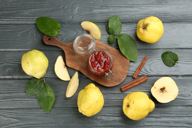 Photo of Delicious quince jam and fruits on grey wooden table, flat lay