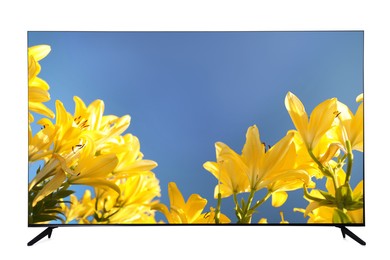 Image of Modern wide screen TV monitor showing beautiful yellow lilies isolated on white