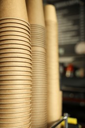 Photo of Stacks of takeaway paper coffee cups in cafe, closeup