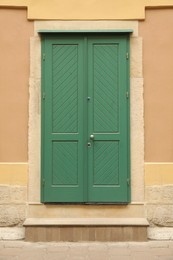 View of building with turquoise wooden door. Exterior design