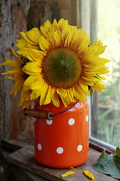 Photo of Bouquet of beautiful sunflowers in tin near window