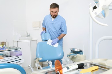 Professional dentist in uniform cleaning workplace  indoors
