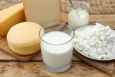 Tasty cottage cheese and other fresh dairy products on wooden table