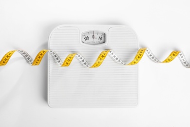Measuring tape and scales on white background, top view. Concept of weight loss