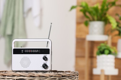 Stylish white radio on wicker stand indoors, space for text