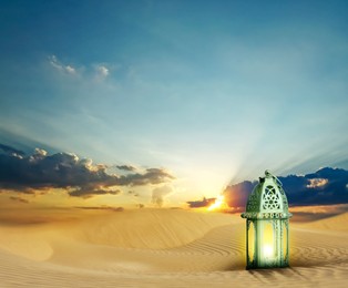 Beautiful Arabic lantern on sand at sunrise, space for text