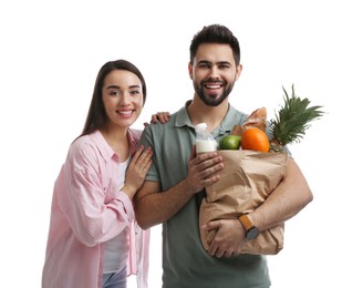 Young couple with groceries on white background