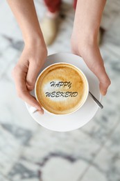 Happy Weekend. Young woman with cup of delicious coffee on blurred background, top view