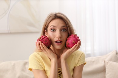 Photo of Young woman with fresh pitahayas at home. Exotic fruits