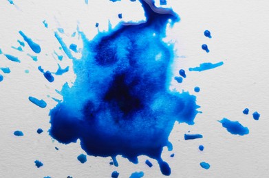 Photo of Blue ink blots on white canvas, top view