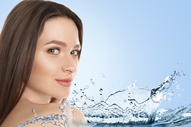Beautiful young woman and splashing water on light background. Spa portrait