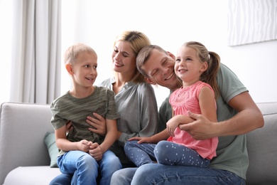Happy family with children on sofa at home