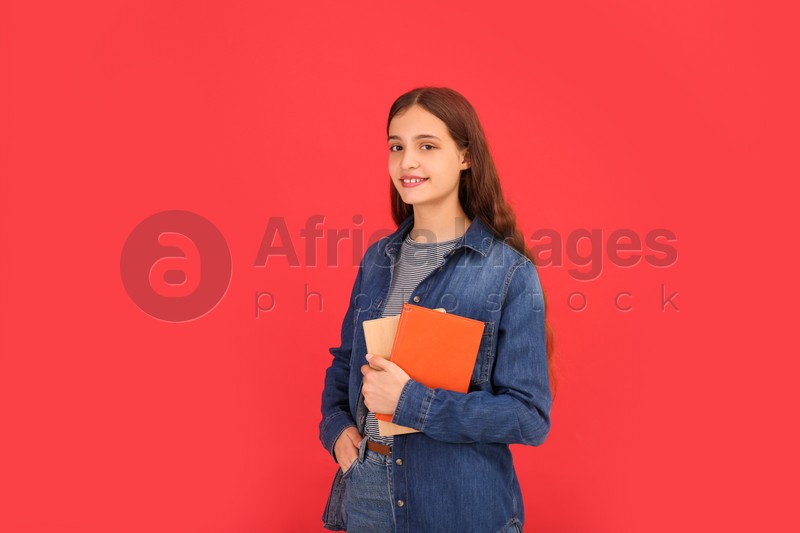 Teenage student with books on red background: Stock Photo | Download on  Africa Images 837825