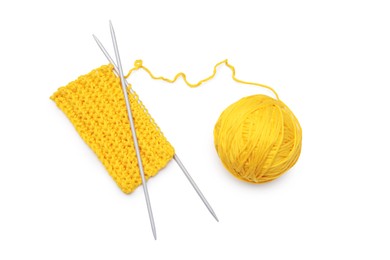 Soft yellow woolen yarn, knitting and metal needles on white background, top view