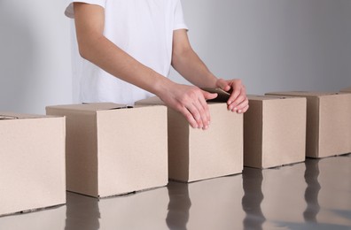 Man folding cardboard boxes at table, closeup. Production line