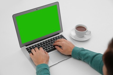 Image of Man using laptop at white desk, closeup. Device display with chroma key