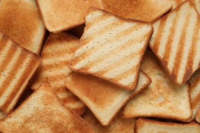 Slices of tasty toasted bread as background, top view