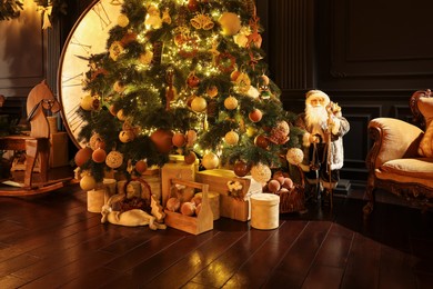 Photo of Beautiful Christmas tree, many gift boxes and vintage armchair in room