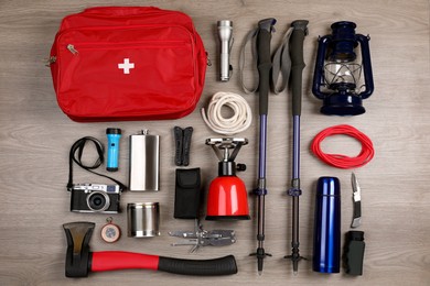 Flat lay composition with different camping equipment on wooden background