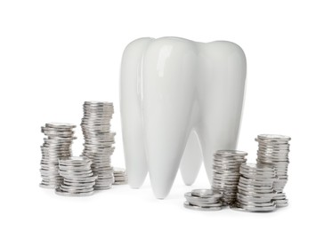 Ceramic model of tooth and coins on white background. Expensive treatment