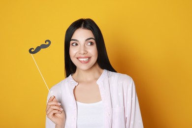 Photo of Emotional woman with fake mustache on yellow background